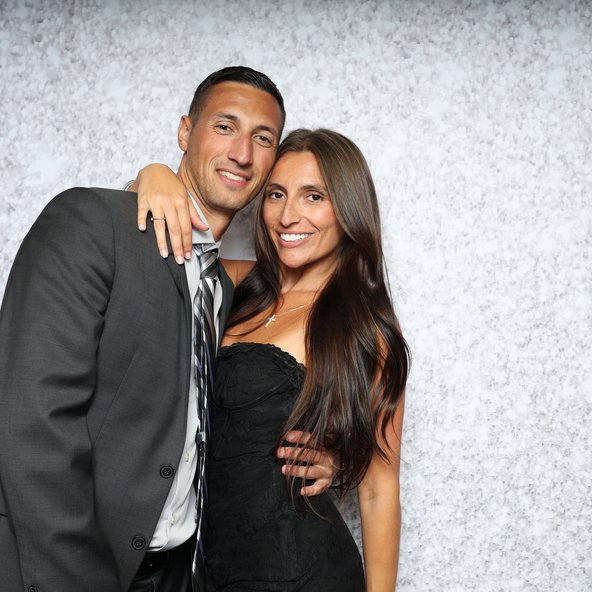 Guests posing together in front of a sparkle backdrop